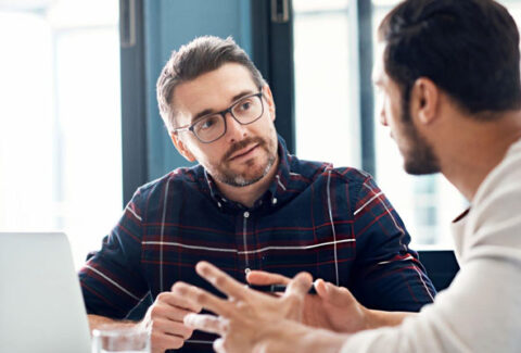 Personas teniendo una conversación profunda que abre nuevos caminos mediante el coaching ontológico.