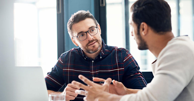 Personas teniendo una conversación profunda que abre nuevos caminos mediante el coaching ontológico.