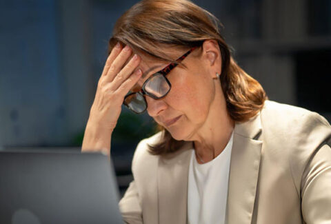 Persona practicando senderismo consciente en la montaña, disfrutando de la soledad para combatir el agotamiento del mundo corporativo.