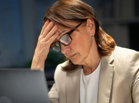 Persona practicando senderismo consciente en la montaña, disfrutando de la soledad para combatir el agotamiento del mundo corporativo.