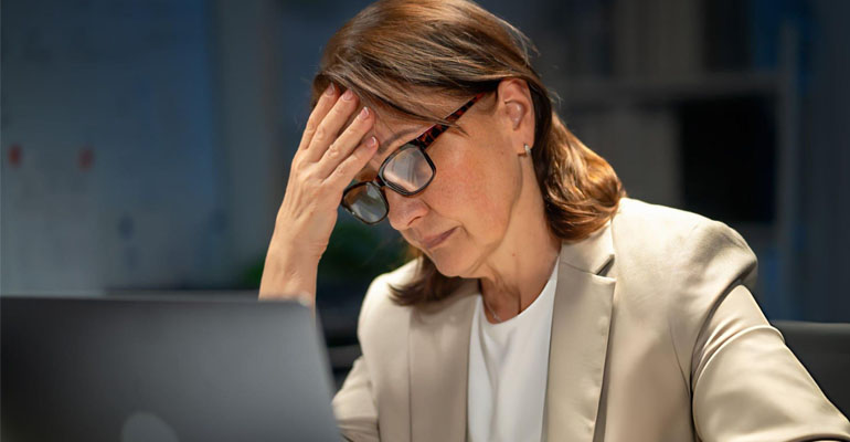Persona practicando senderismo consciente en la montaña, disfrutando de la soledad para combatir el agotamiento del mundo corporativo.