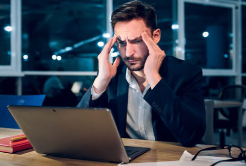 Gerente medio mostrando señales de burnout laboral en oficina